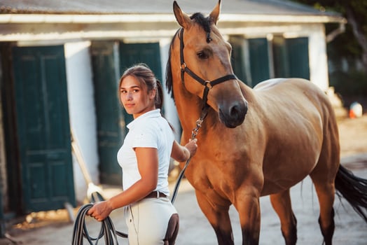 Getting ready for the ride. Horsewoman in white uniform with her horse at farm. Ready for the ride photo