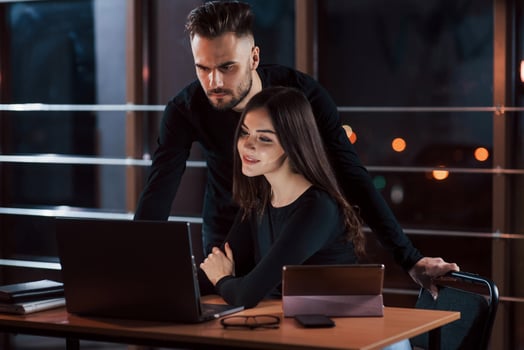 Bearded modern looking guy. Team of young business people works on their project at night time in the office photo