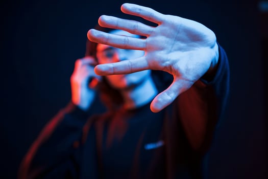 Focused photo. Studio shot in dark studio with neon light. Portrait of serious man photo