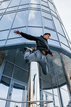 Young man doing parkour in the city at daytime. Conception of extreme sports photo