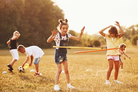 Girls with circle fitness tool. Group of kids have active weekend in the field photo