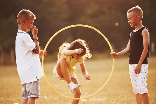 Jumping through the circle fitness tool. Kids having fun in the field photo