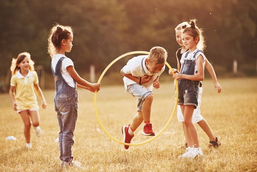 Jumping through the circle fitness tool. Kids having fun in the field photo
