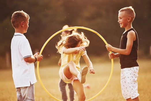 Jumping through the circle fitness tool. Kids having fun in the field photo