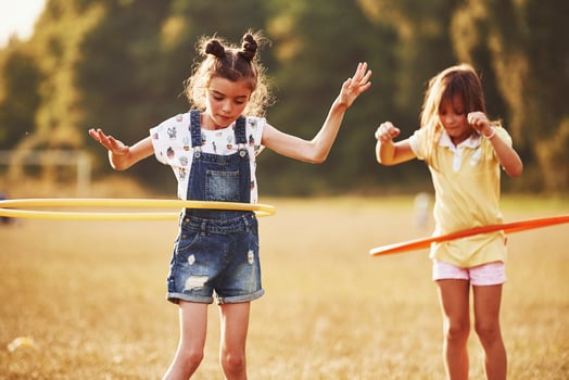 Girls with circle fitness tool. Group of kids have active weekend in the field photo