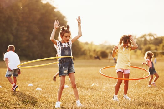 Girls with circle fitness tool. Group of kids have active weekend in the field photo