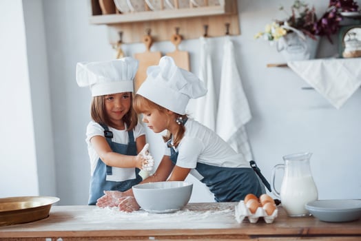 Family kids in white chef uniform preparing food on the kitchen photo