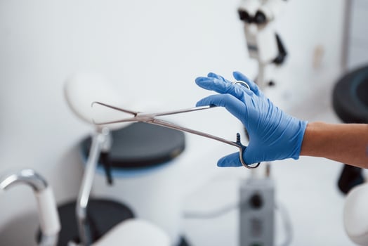Close up view of female doctor hands that holds forceps photo