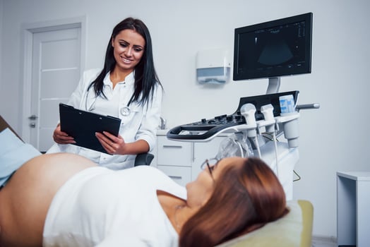 Female doctor talks about results of ultrasound for a pregnant woman in the hospital photo