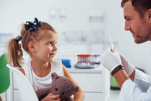 Blood sampling. Little girl with her teddy bear is in the clinic with doctor photo