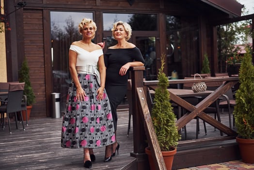 Women in formal clothes stands together near building at daytime photo