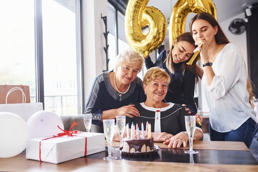 Balloons with number 60. Senior woman with family and friends celebrating a birthday indoors photo
