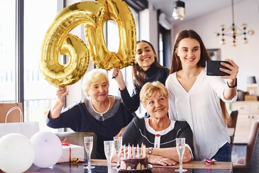 Balloons with number 60. Senior woman with family and friends celebrating a birthday indoors photo
