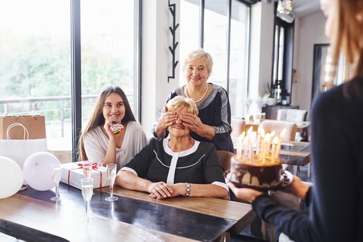 Senior woman with family and friends celebrating a birthday indoors photo
