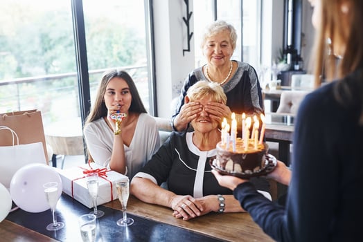 Senior woman with family and friends celebrating a birthday indoors photo