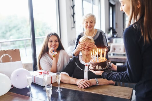 Senior woman with family and friends celebrating a birthday indoors photo