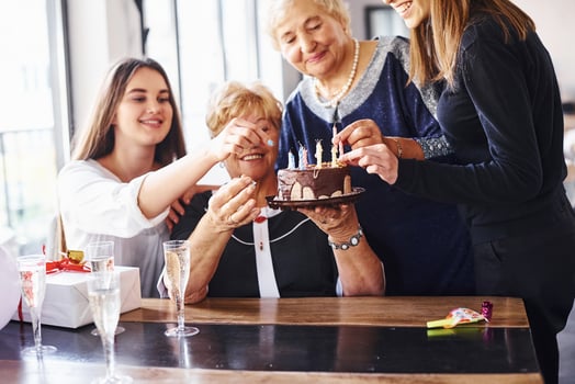 Senior woman with family and friends celebrating a birthday indoors photo