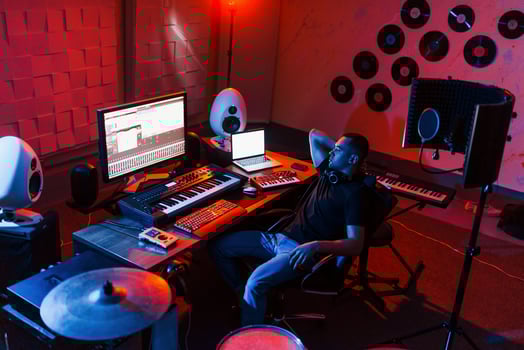 Sound engineer working and mixing music indoors in the studio near drum kit photo