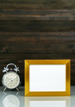 Mockup with golden frame and alarm clock photo