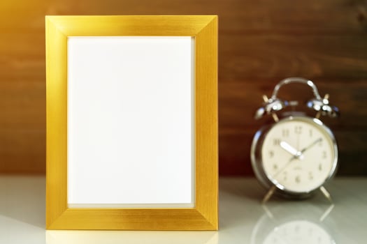 Mockup with golden frame and alarm clock photo