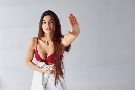 Stop gesture. Woman in underwear in the studio against white background photo