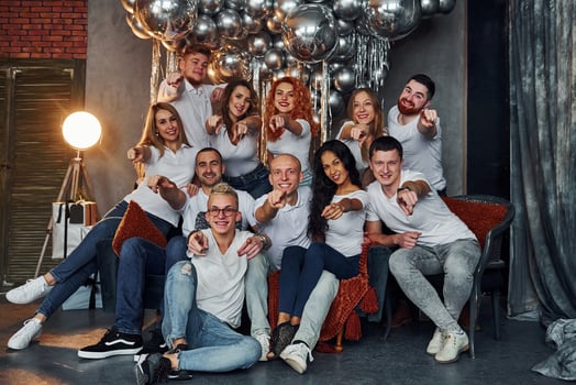 Happy young people celebrating New Year in christmas decorated room with lighting equipment photo