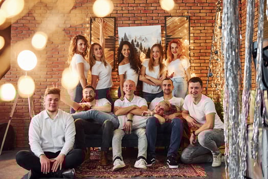 Smiling young people celebrating New Year in cozy christmas decorated room together photo