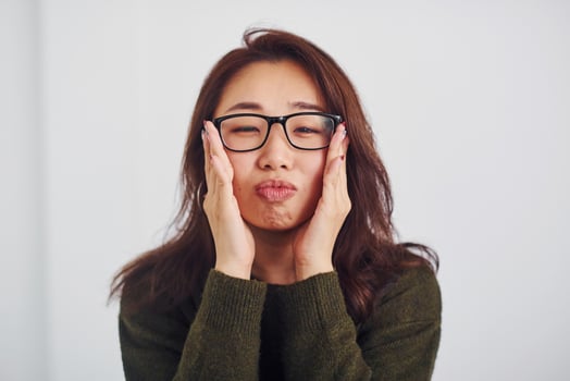 Portrait of happy asian young girl in eyewear that standing indoors in the studio against white background photo