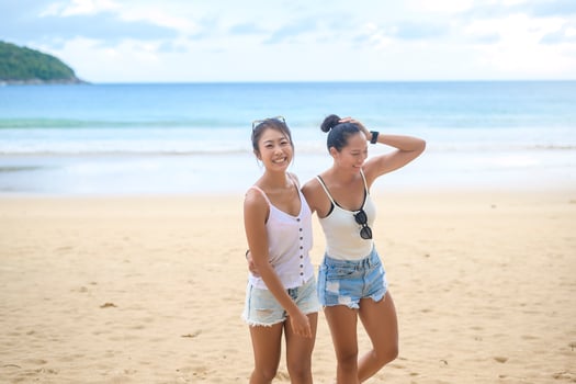 Two attractive women friends enjoying and relaxing on the beach,  Summer, vacation, holidays, Lifestyles concept. photo
