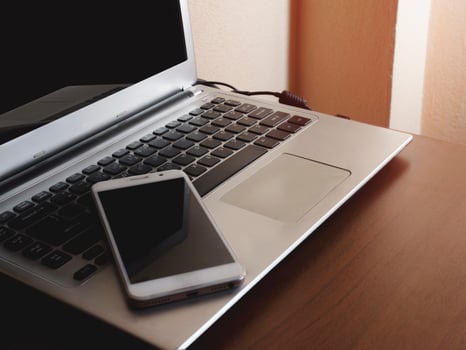 Smartphone black screen on a laptop computer black keyboard on a desk office with copy space and composition. Concept office business on the internet and social photo