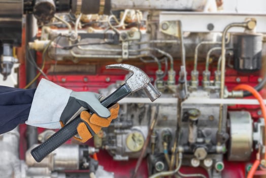 Hand in glove holding hammer with engine photo