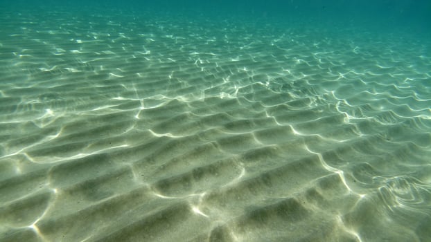 sand bottom underwater swimming in turquoise lagoon photo