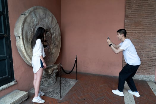 ROME, ITALY - JUNE 15 2019 - Tourist testing the mouth of truth mask photo