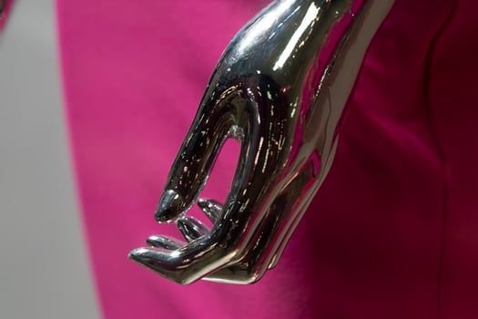 Silver woman mannequin hand detail with pink dress photo