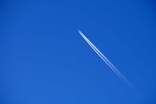 Airplane trails tracks chemtrails in the deep blue sky photo