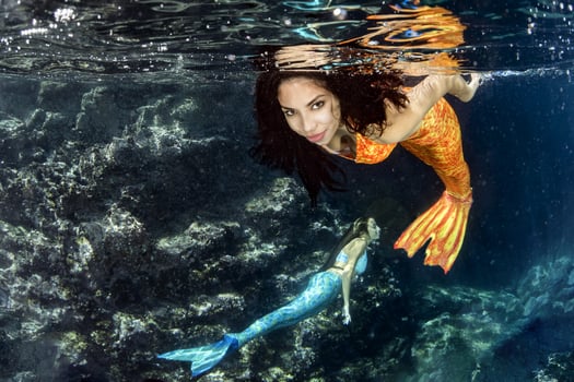 Mermaid swimming underwater in the deep blue sea photo
