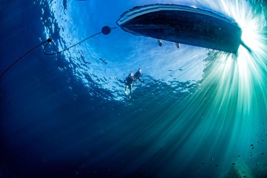 boat ship from underwater blue ocean with sun rays photo