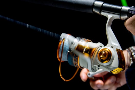 Fishing reel tackle isolated on black photo