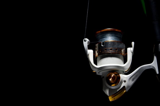 Fishing reel tackle isolated on black photo