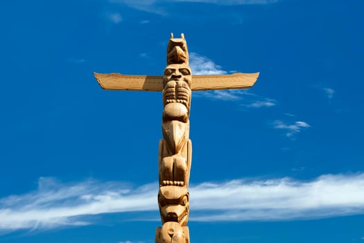 A totem wood pole in the blue cloudy background photo