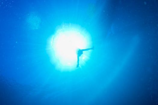 backlight diver underwater coming to the deep ocean photo
