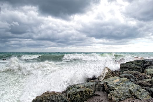 sea in tempest on rocks of italian village photo