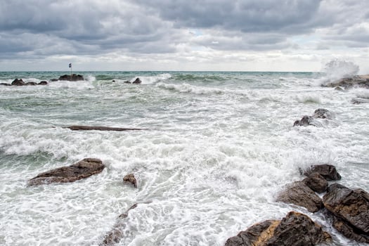sea in tempest on rocks of italian village photo