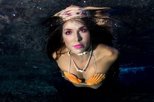 Mermaid swimming underwater in the deep blue sea photo