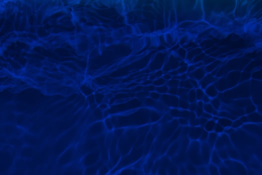 Defocus blurred blue water in swimming pool rippled water detail background. Water surface in the sea, ocean background. Water is an inorganic, transparent, tasteless, odorless, and nearly colorless. photo