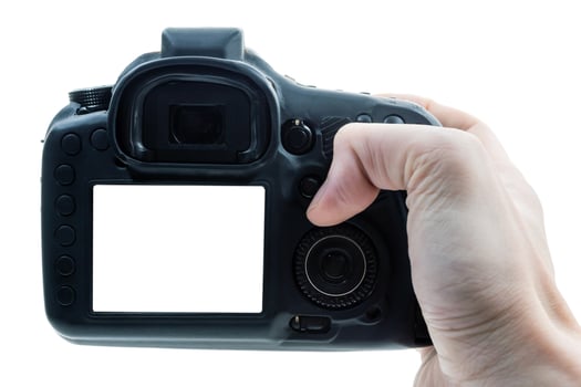 Close up of male hand press on button of a black digital camera. photo
