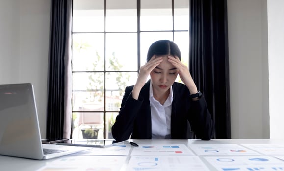 Young Asian businesswoman working on a tablet, is stressed has a headache and thinks hard at the office. photo