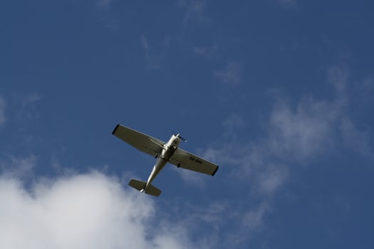 A plane flying through a cloudy blue sky photo
