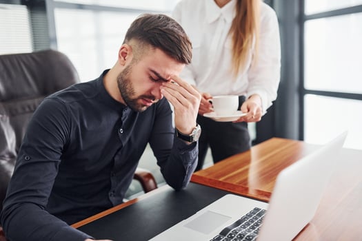 Guy feels bad. Woman and man in formal clothes working together indoors in the office by table photo