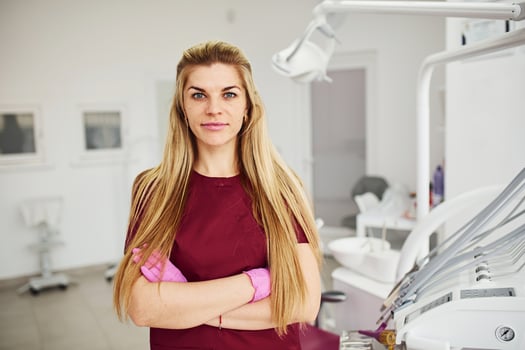 Young female dentist in uniform standing in stomatology office photo